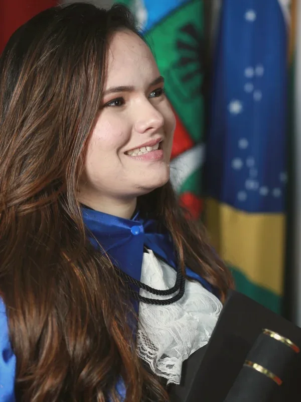 Thalyta de beca e faixa azul, maquiagem clássica de formatura