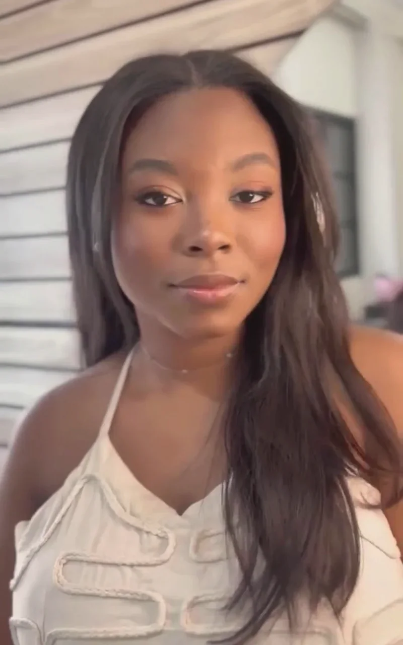 Agatha, cliente, com acabamento luminoso na pele negra e cabelo solto