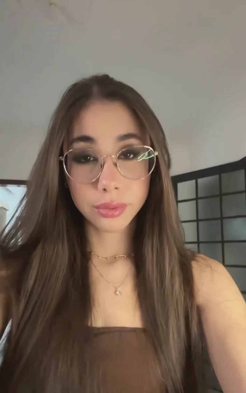 Gabriela de óculos no estúdio, maquiagem pronta, sorrindo